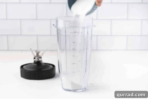 Pouring granulated sugar into a blender