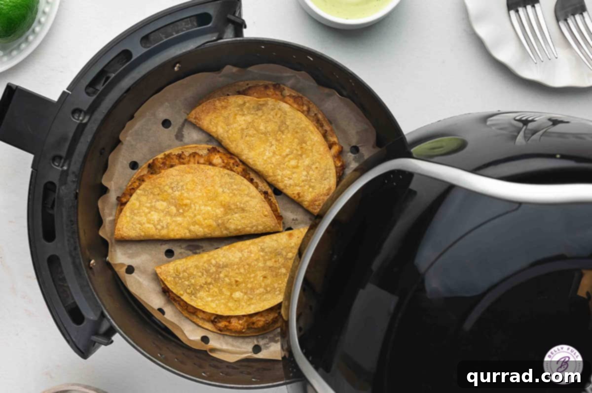 Golden Crispy Air Fryer Chicken Tacos Three perfectly air-fried chicken tacos with a golden-brown crispy shell, ready to be served and enjoyed.