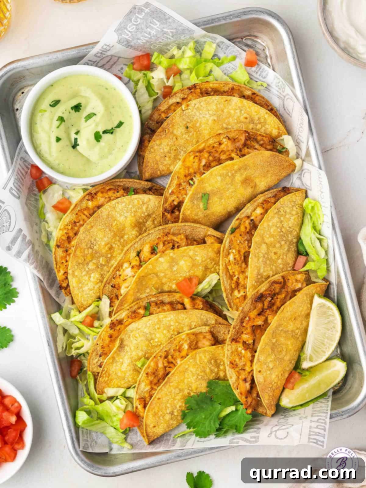 Serving Air Fryer Chicken Tacos with Avocado Dipping Sauce A beautifully arranged platter of air fryer chicken tacos, accompanied by a small bowl of the creamy avocado cilantro dipping sauce, inviting you to savor every crispy bite.