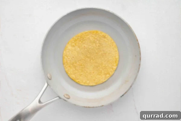 Heating a corn tortilla in a skillet to make it pliable