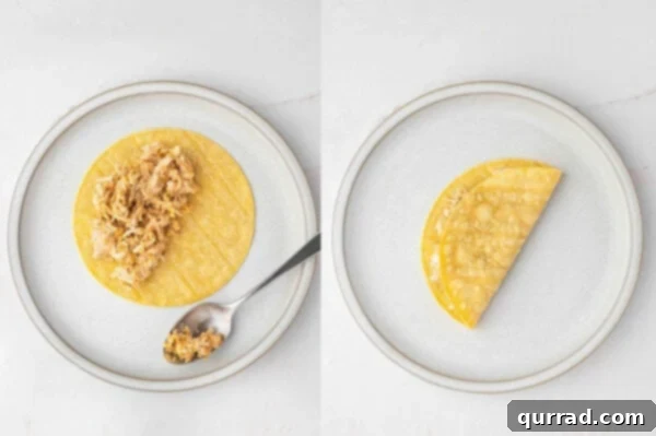 A corn tortilla filled with the creamy chicken and cheese mixture, folded in half and ready for air frying.