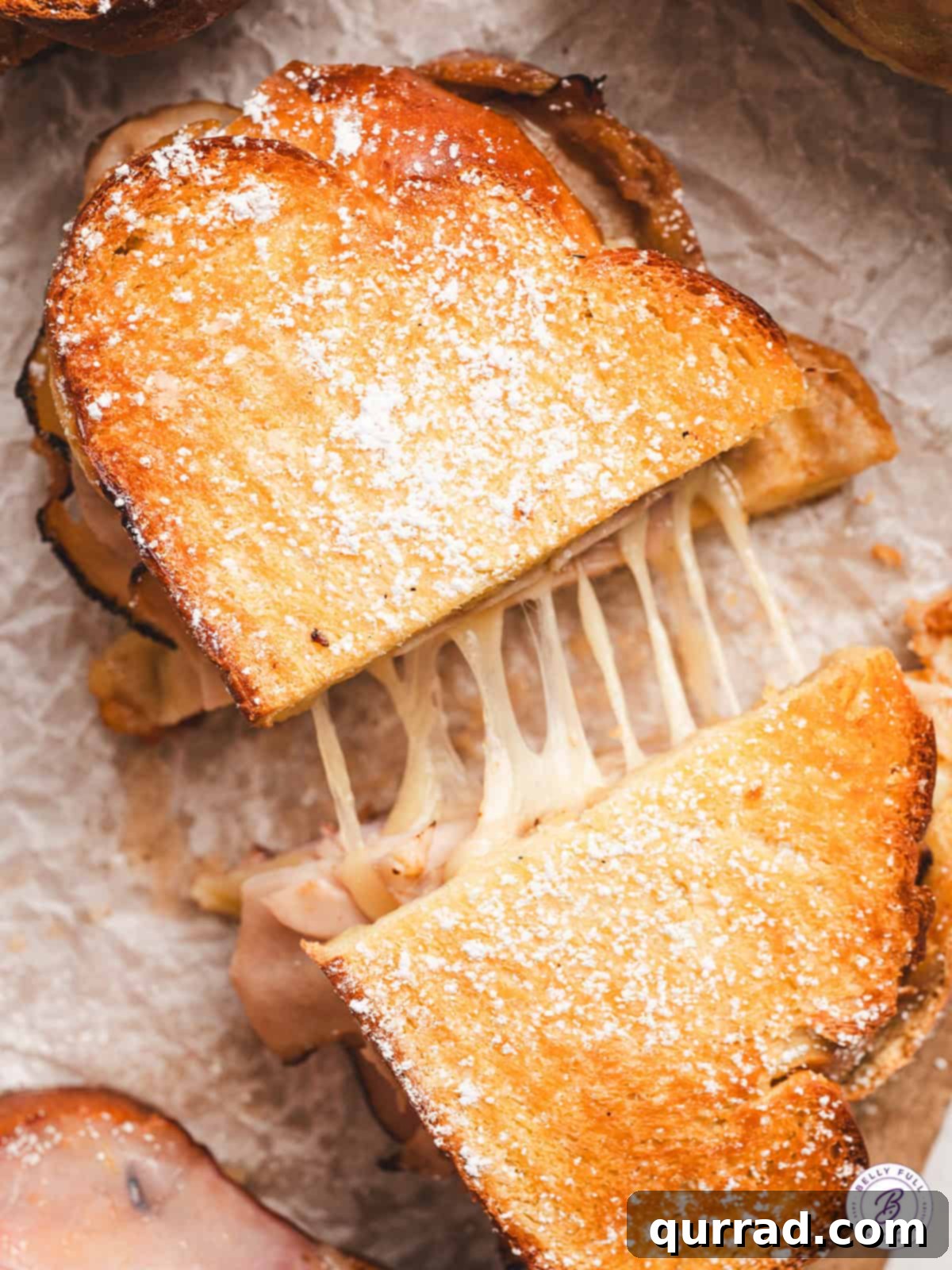 Overhead view of a Monte Cristo grilled cheese cut in half, showing the melted cheese and juicy layers between two halves