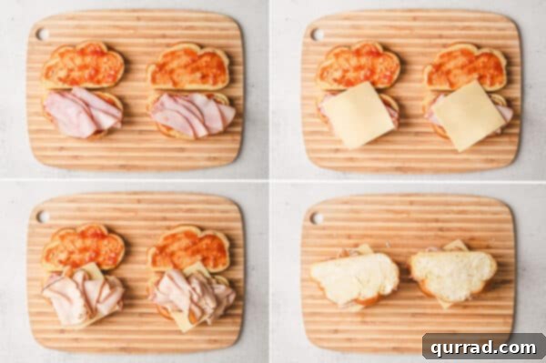 Ham, turkey, and Gruyere cheese added to the bread slices, ready to be topped