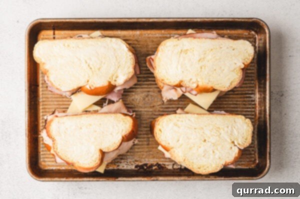 Assembled Monte Cristo sandwiches placed on a baking sheet, ready for the oven
