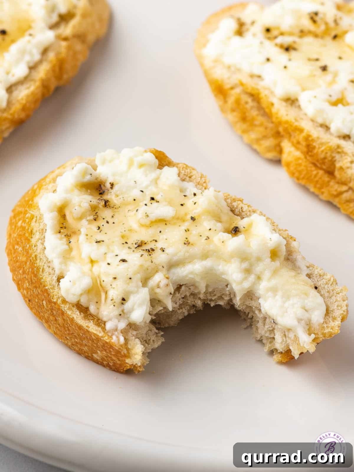 Crafting Fresh Ricotta at Home 5 bite taken out of crostini topped with ricotta cheese and honey