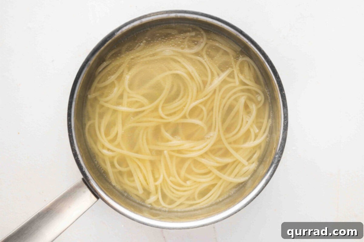 A pot of linguine pasta boiling on the stove