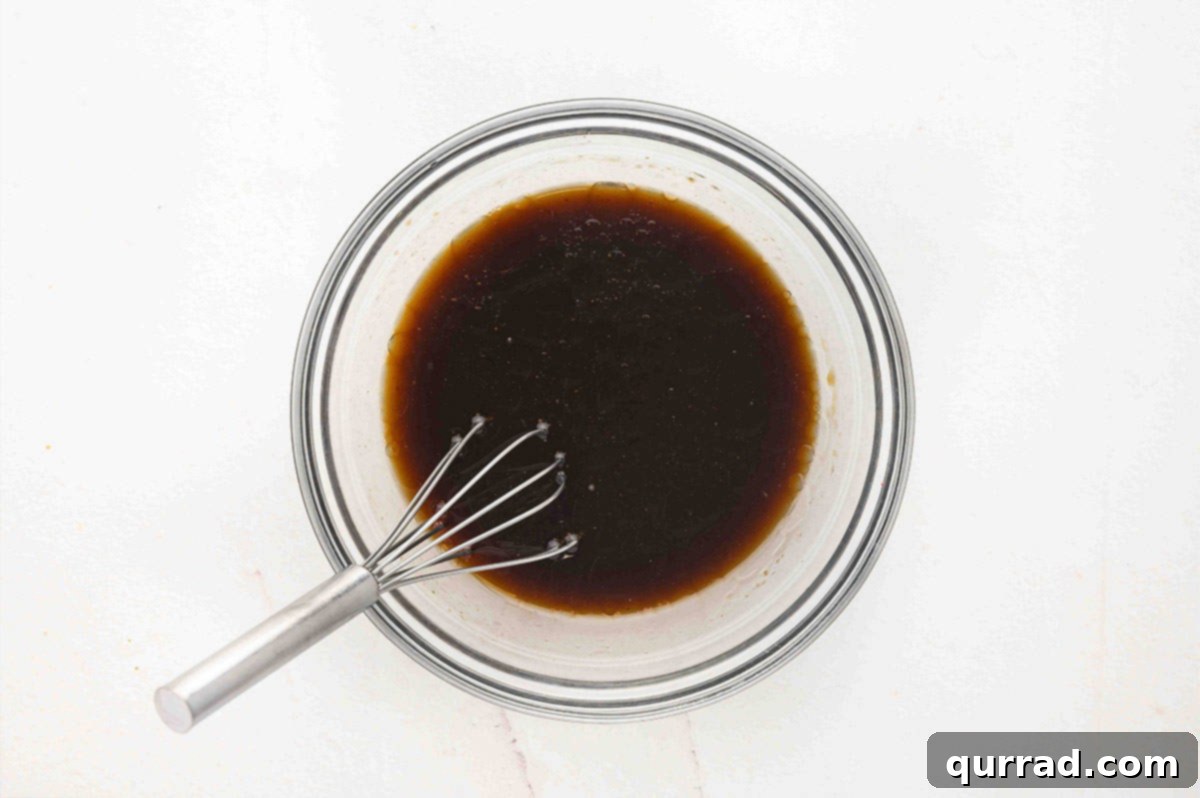 A small bowl with sauce ingredients being whisked together