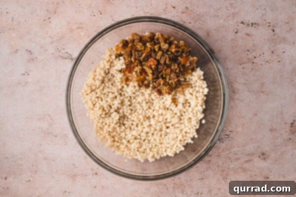 Golden raisins added to a bowl with couscous
