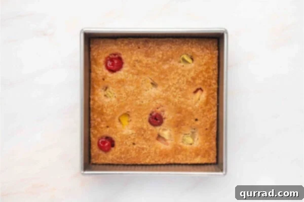 Cuppa Cake Delight 7 Overhead view of a golden-brown Cuppa Cuppa Cake in a square pan, freshly baked and glistening.