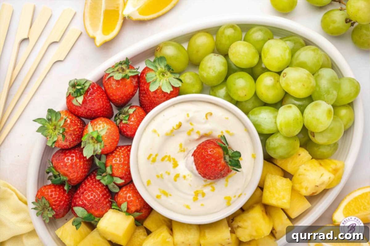 Zesty Lemonade Fruit Dip 7 A large platter generously filled with an assortment of colorful fresh fruits, with a bowl of creamy lemonade fruit dip at its center.