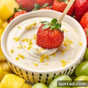 Zesty Lemonade Fruit Dip 2 Dipping a strawberry in lemonade fruit dip
