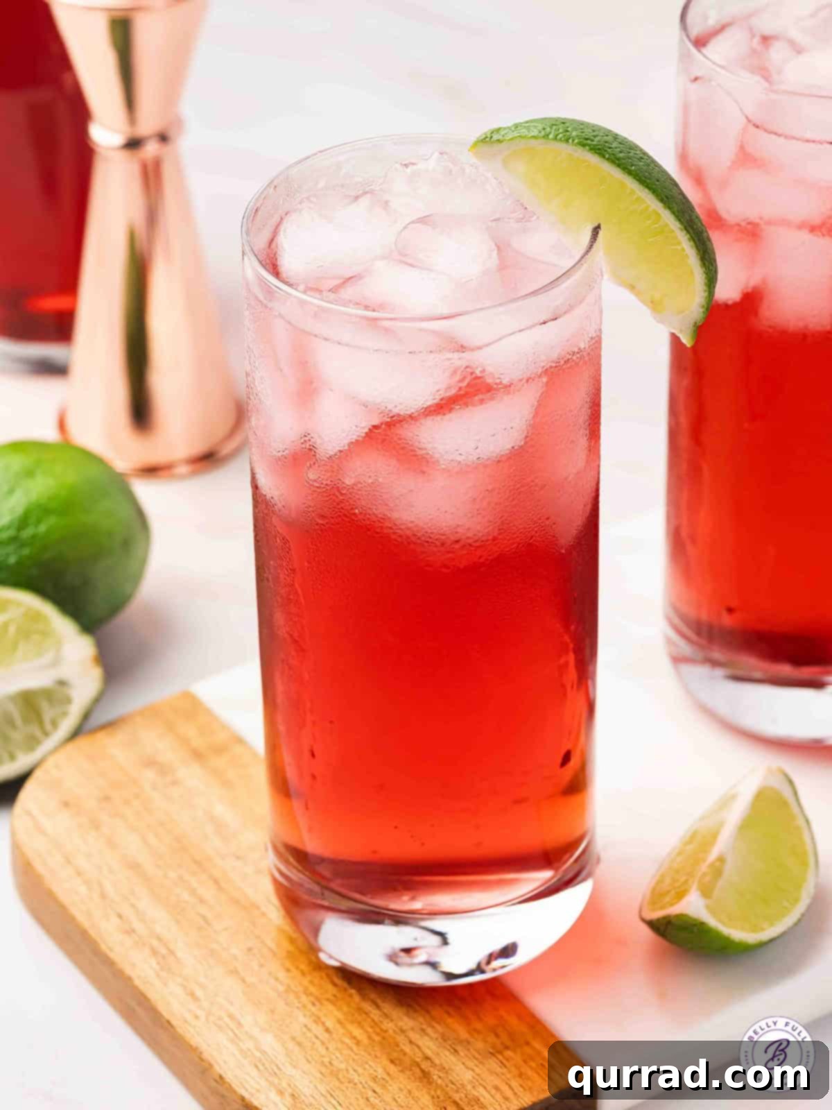 A perfectly prepared Woo Woo cocktail, garnished with a vibrant lime wedge, inviting you to take a sip.