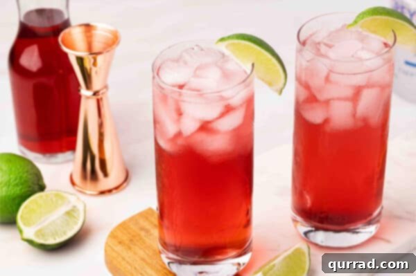 A perfectly mixed Woo Woo cocktail, garnished with a fresh lime wedge, resting on a coaster.