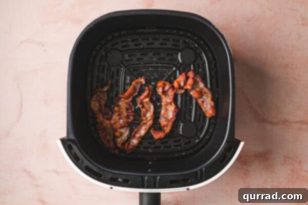Perfectly cooked, crispy bacon strips fresh out of the air fryer.