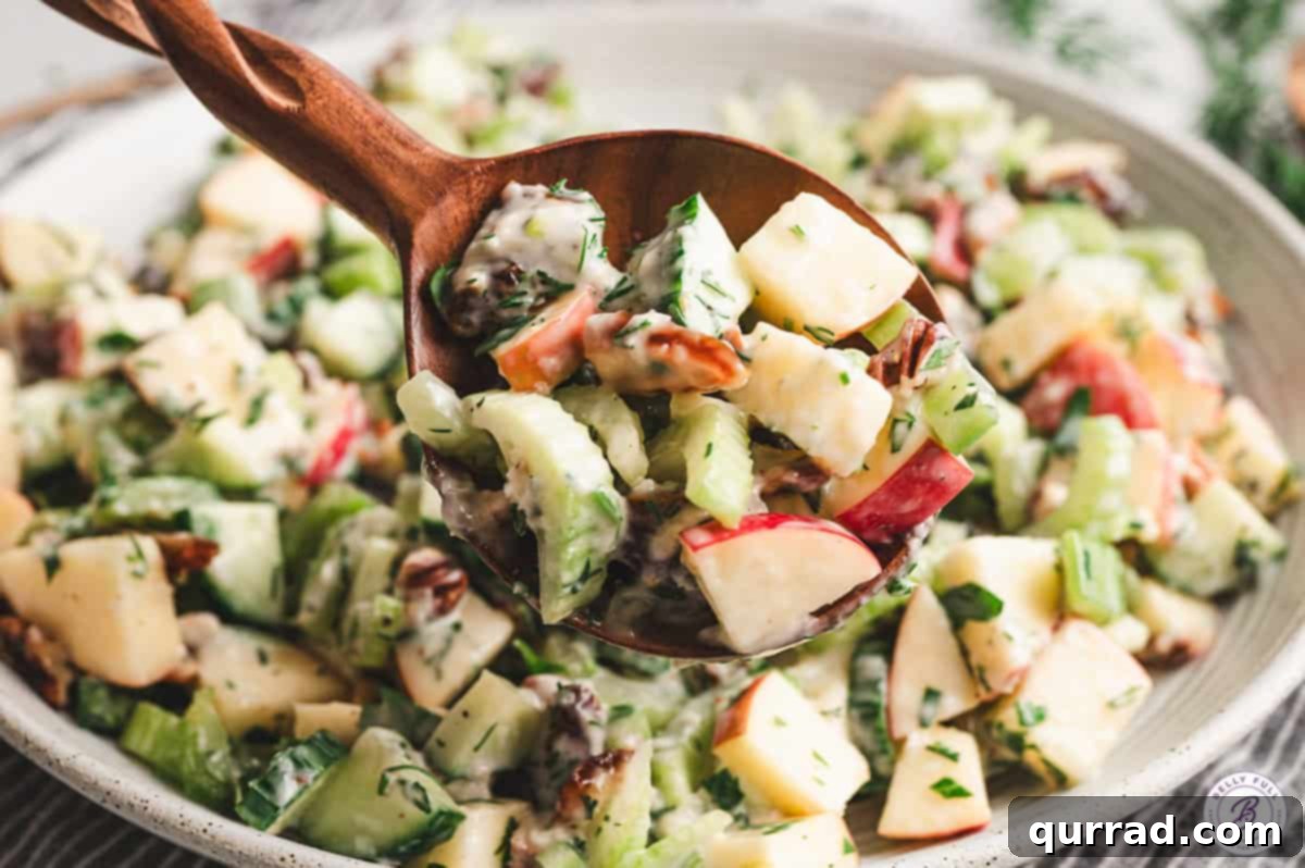 A wooden spoon holding a perfect scoop of Apple Date Celery Salad, showing the rich texture and vibrant mix of ingredients, ready to be enjoyed.