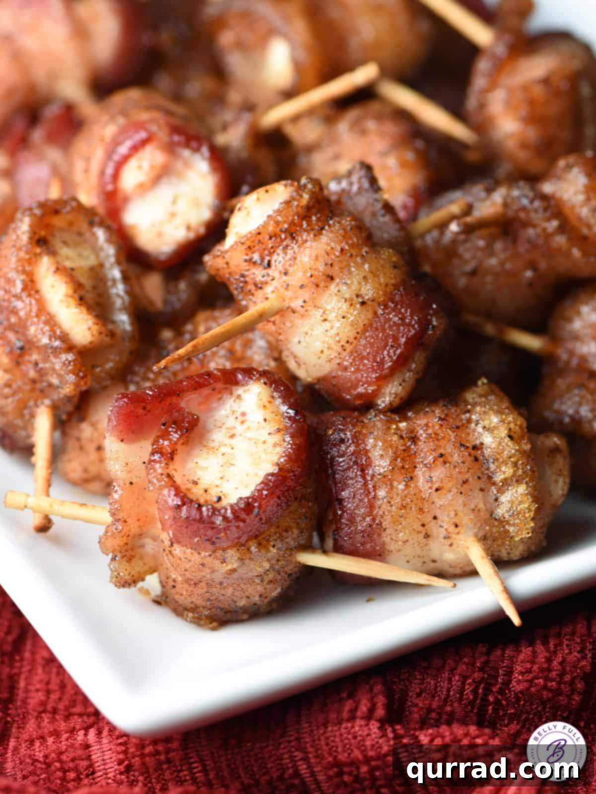 Crispy Bacon Chicken Poppers 2 A serving platter brimming with golden-brown bacon wrapped chicken bites, each secured with a toothpick, ready to be enjoyed.