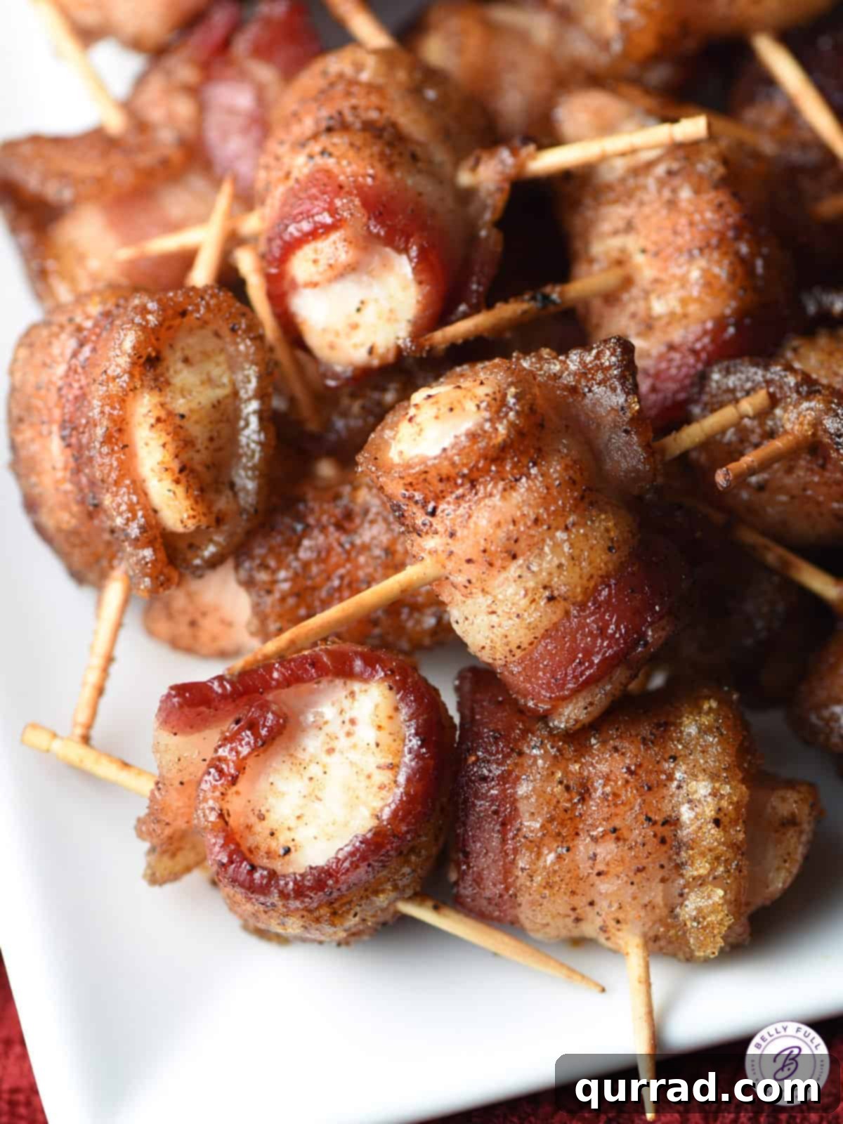Crispy Bacon Chicken Poppers 4 A generously piled plate of golden-brown and crispy bacon wrapped chicken bites, ready to be served at a party.