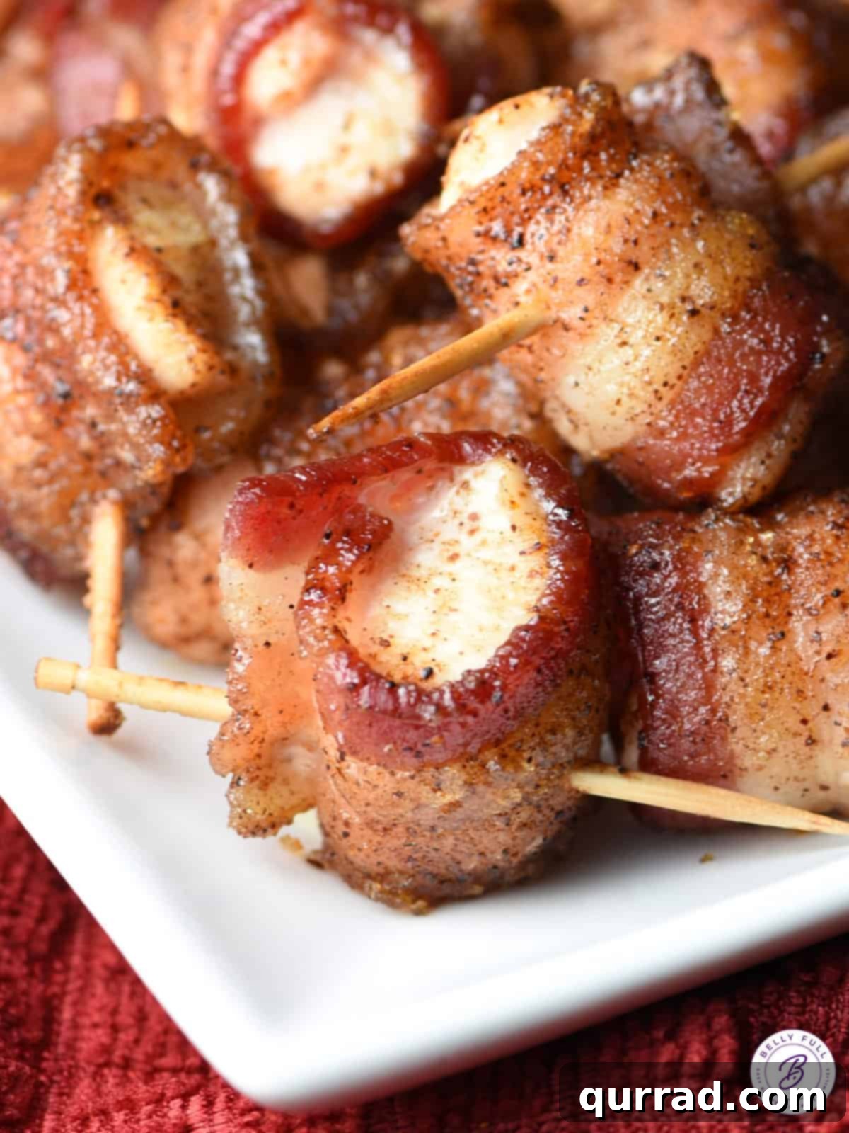 Crispy Bacon Chicken Poppers 5 An appetizing close-up of a perfectly cooked bacon wrapped chicken bite, showcasing its crispy bacon and sticky glaze.