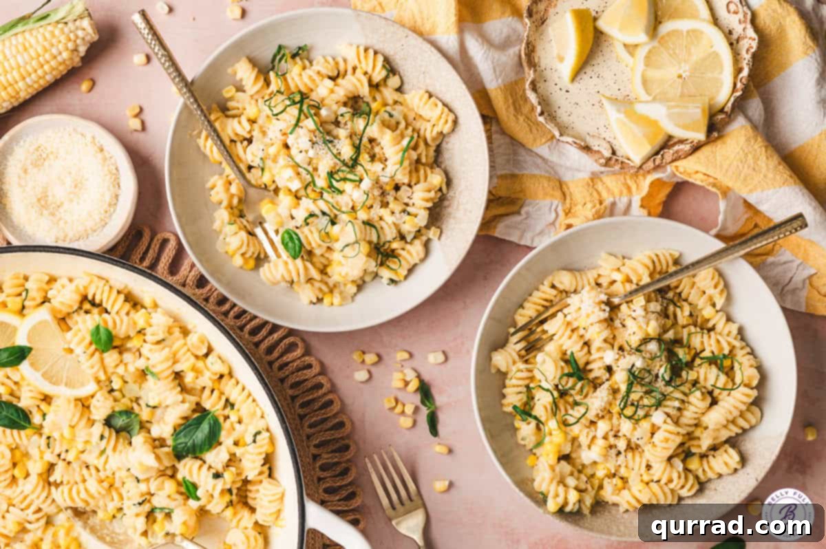 Overhead view of two plates of creamy corn pasta, garnished beautifully.