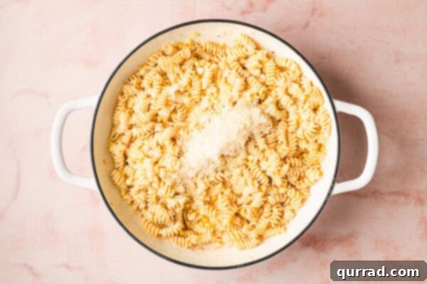 Creamy corn pasta simmering gently in the pan, with cheese fully incorporated.