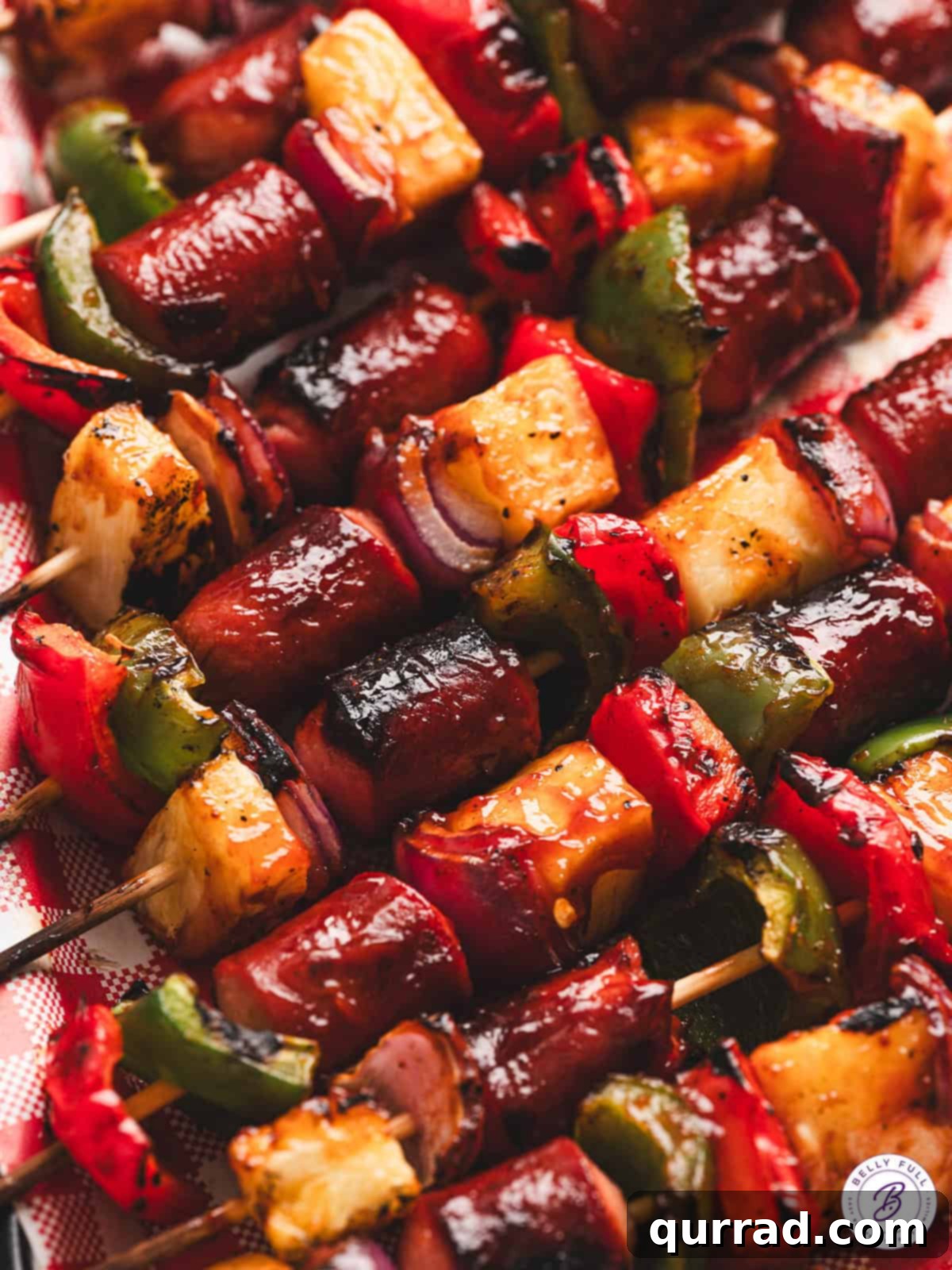 Elevate your summer grilling with these amazing Grilled Hot Dog Kabobs, featuring colorful peppers, zesty onions, and juicy pineapple for a delicious kid-approved BBQ treat! Overhead view of vibrant grilled hot dog kabobs on a platter with fresh ingredients around.