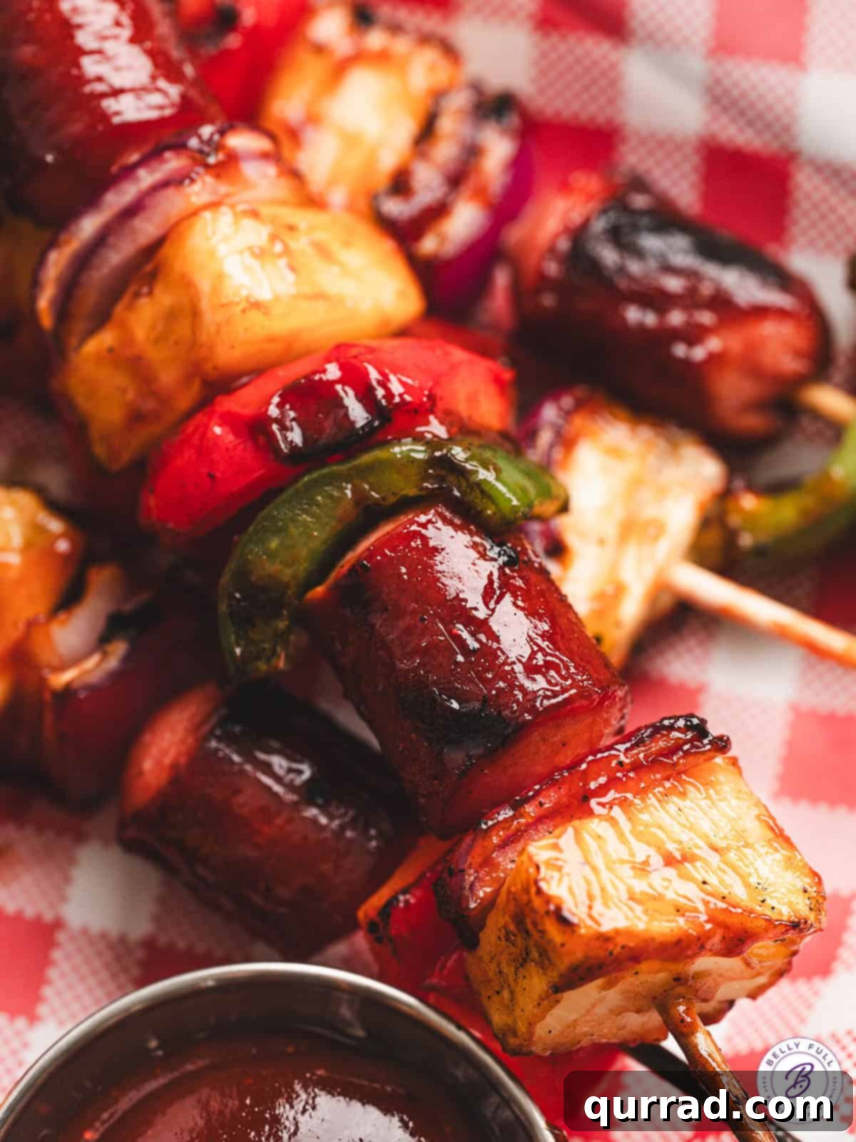 Get ready for summer with these mouthwatering Grilled Hot Dog Kabobs – a family favorite featuring hot dogs, fresh vegetables, and tropical pineapple, all coated in a tangy BBQ sauce and grilled to perfection. Closeup shot of caramelized and perfectly grilled hot dog kabobs, showcasing the rich BBQ glaze and vibrant colors of the ingredients.
