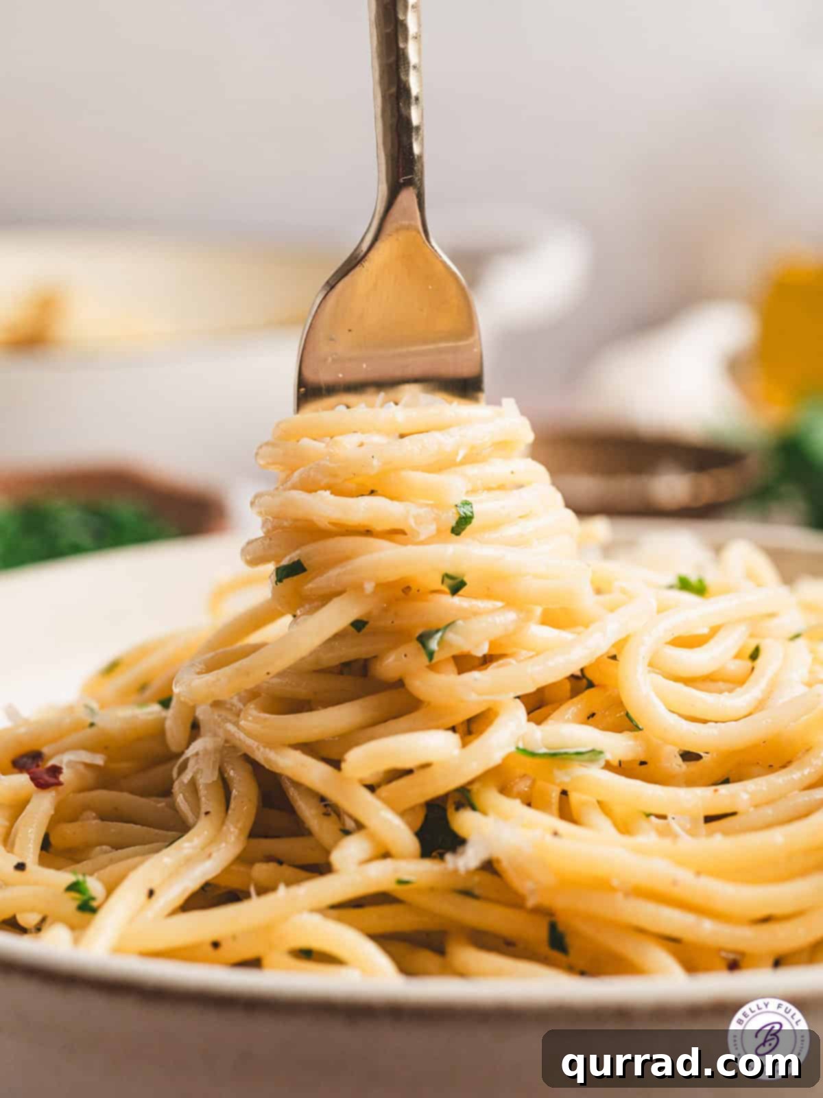 Pasta tossed with olive oil, garlic, and parmesan cheese for a simple and delicious Spaghetti Aglio e Olio recipe, ready in just 25 minutes! A fork twirling a generous portion of Spaghetti Aglio e Olio, ready to be eaten