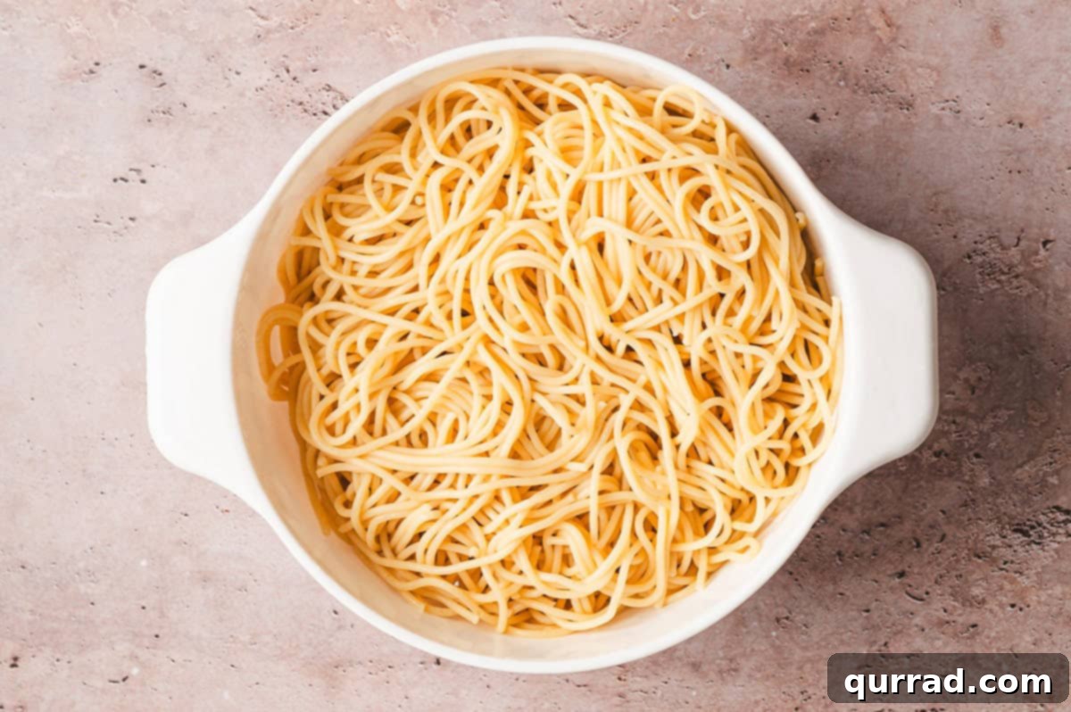 Garlic and Olive Oil Spaghetti 3 Freshly cooked spaghetti being drained in a colander, steam rising gently