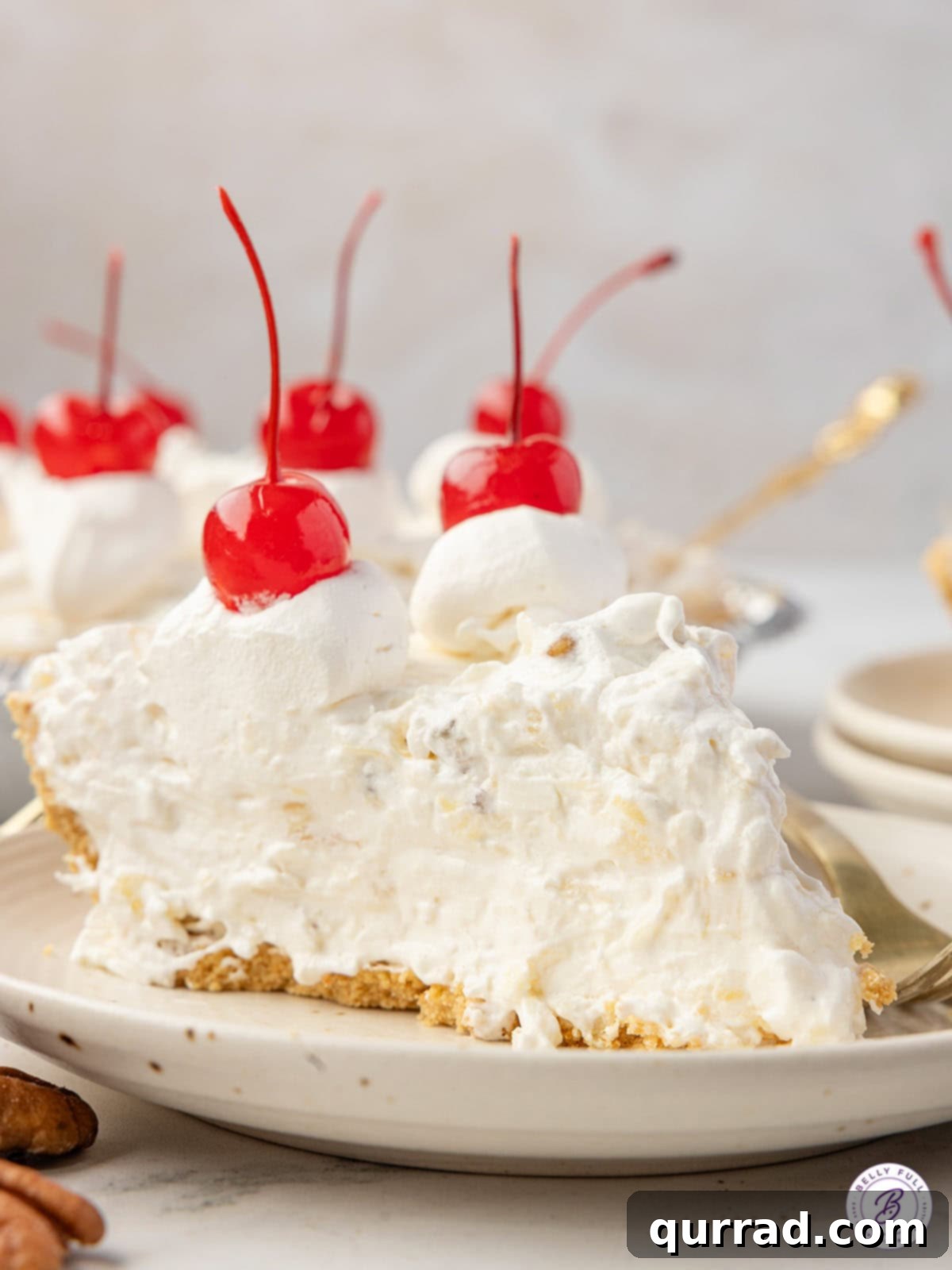 slice of Million Dollar Pie on a plate, topped with whipped cream and a cherry
