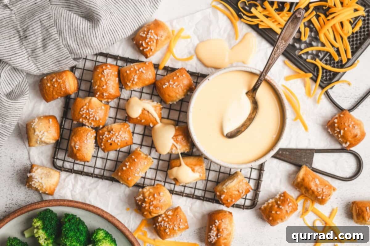 Liquid Gold Cheese 9 A bowl of creamy cheese sauce with a spoon, surrounded by ingredients like shredded cheese and milk.