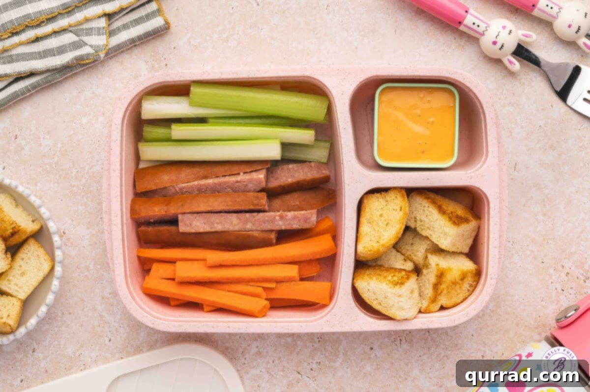 Delicious & Easy School Lunches 12 Bento box lunch with toasted bread cubes, celery, carrots, fully cooked Kielbasa, and Thousand Island dressing for dipping.