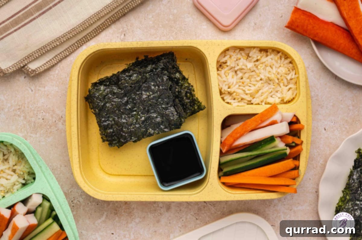 Delicious & Easy School Lunches 10 Build Your Own Sushi bento box with roasted seaweed, sweet rice, imitation crab, sliced carrots, sliced cucumber, and soy sauce.
