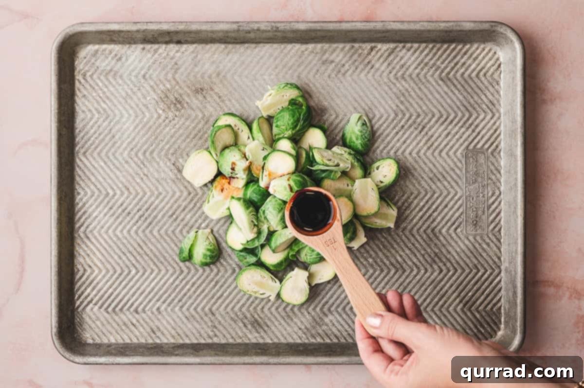 Balsamic Glazed Brussels Sprouts with Crispy Bacon 4 Seasoning halved Brussels sprouts on a baking sheet.