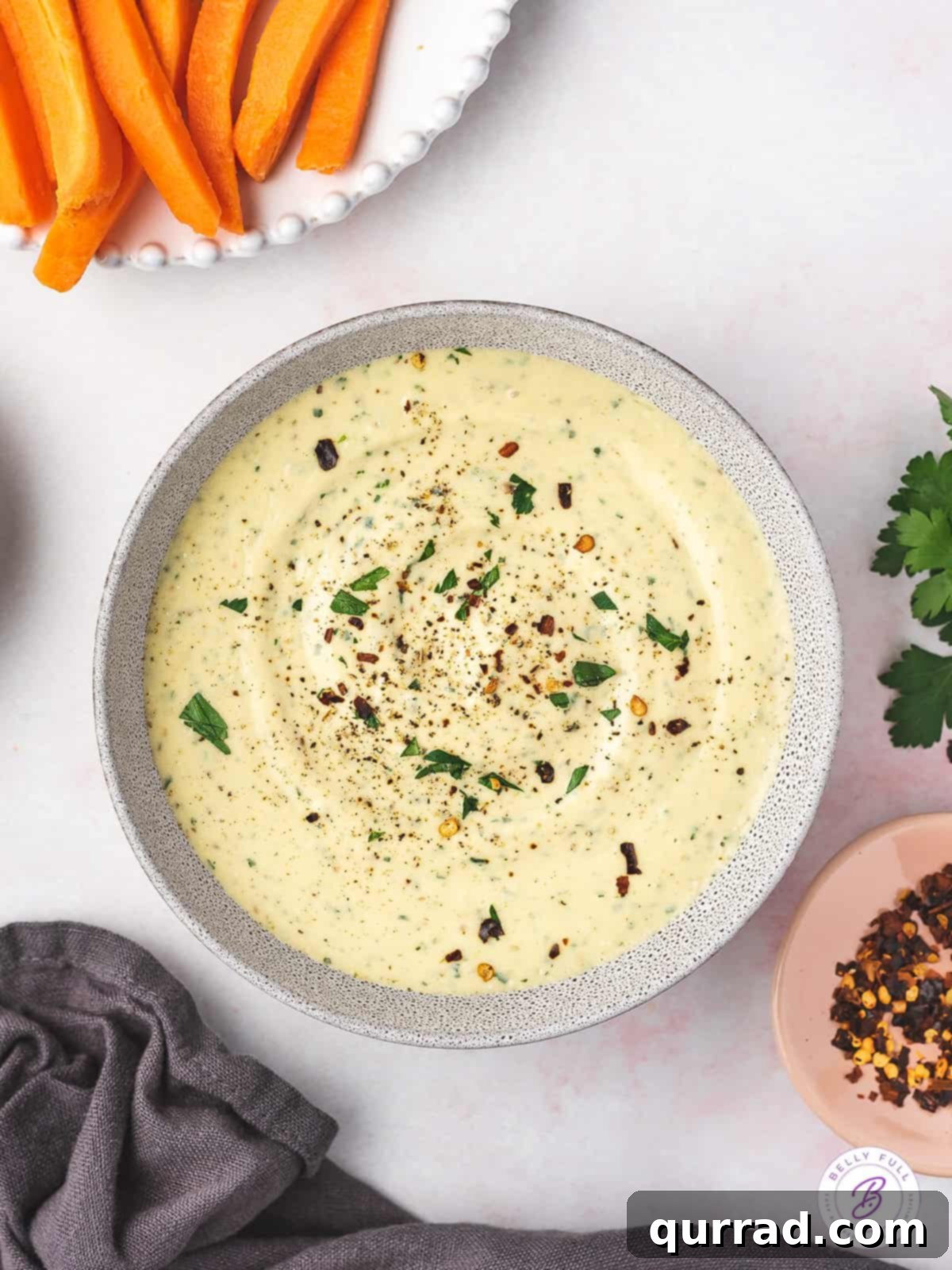 overhead bow of white bean dip garnished with fresh herbs