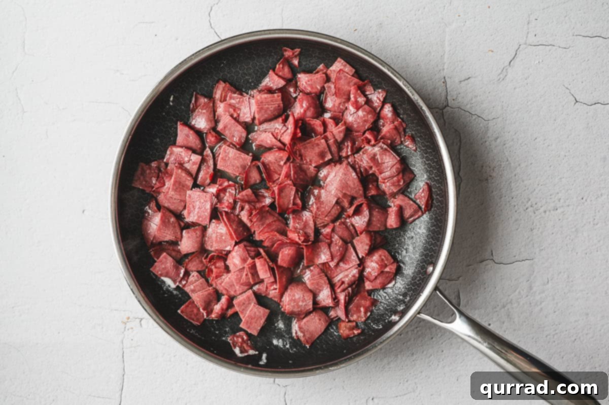 Savory Shredded Beef in Cream Sauce 5 Chopped chipped beef pieces sautéing in a nonstick skillet with melted butter.