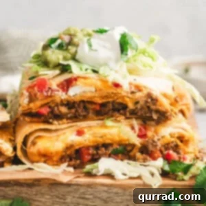 Stacked squares of Crunchwrap Casserole showing beef, cheese, and red peppers, topped with shredded lettuce, sour cream, guacamole, and cilantro.