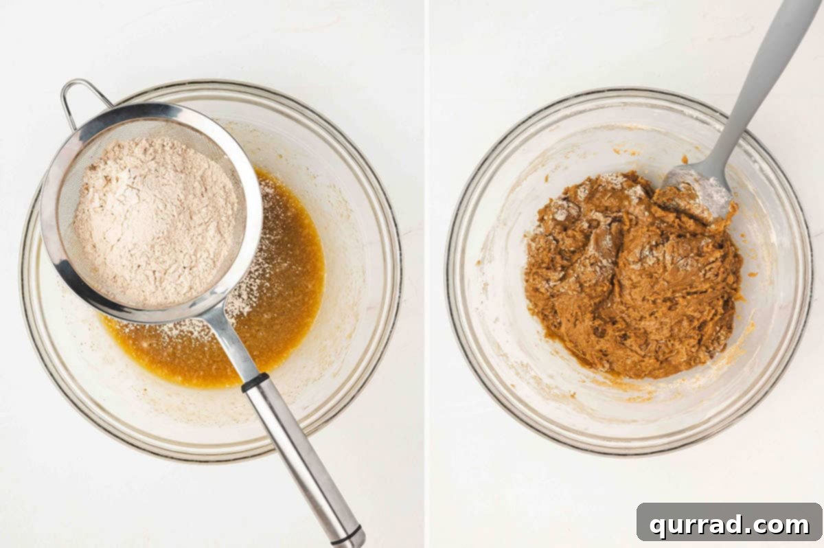 The process of sifting dry ingredients—flour, pumpkin pie spice, baking powder, baking soda, and salt—directly into the bowl of wet ingredients, followed by gentle stirring to form a thick, cohesive batter.