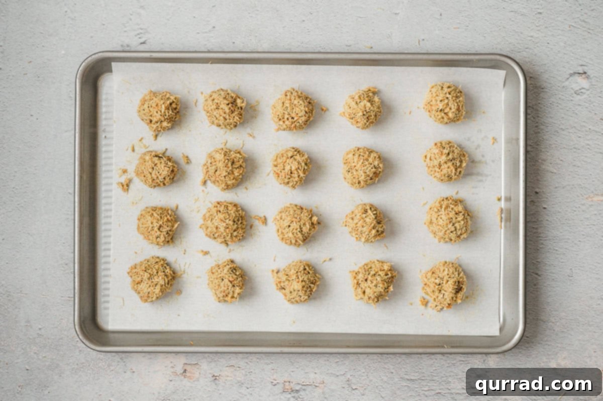 Decadent Dubai Truffles 7 Rows of kataifi pistachio truffle balls arranged on a parchment-lined baking sheet.