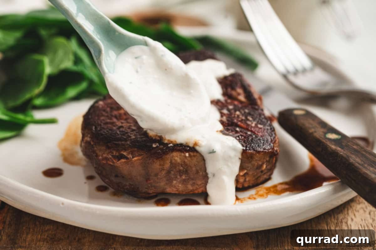 Horseradish Cream 7 Creamy horseradish sauce being spooned over a cooked steak on a dinner plate.
