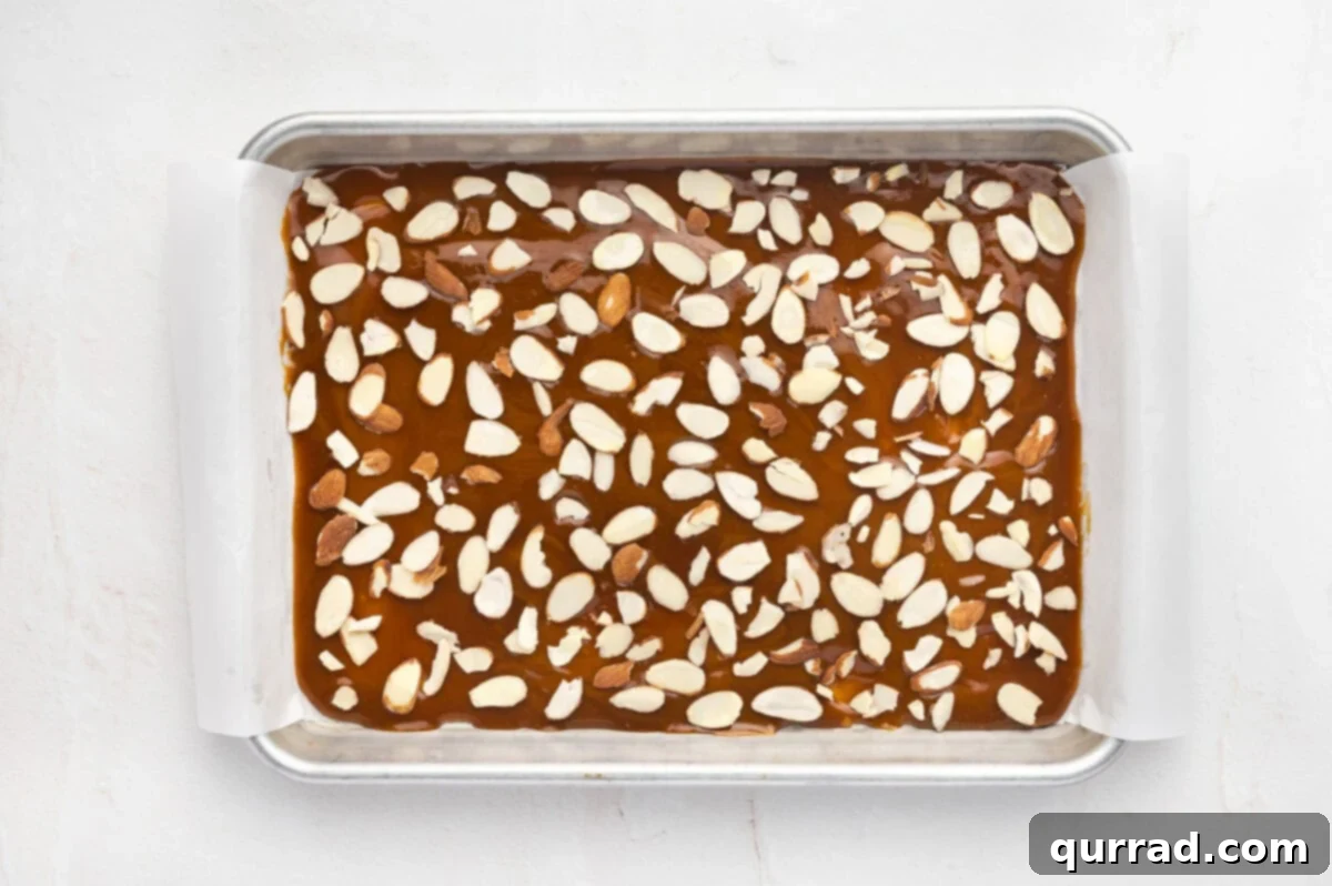 Sprinkle sliced almonds over the hot toffee. Sliced almonds sprinkled on top of the toffee