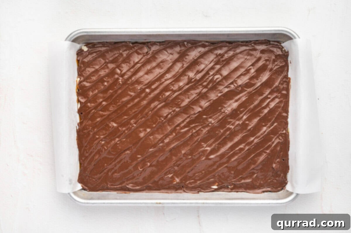 Spread melted chocolate over the almond-covered toffee. Melted chocolate chips spread over the toffee