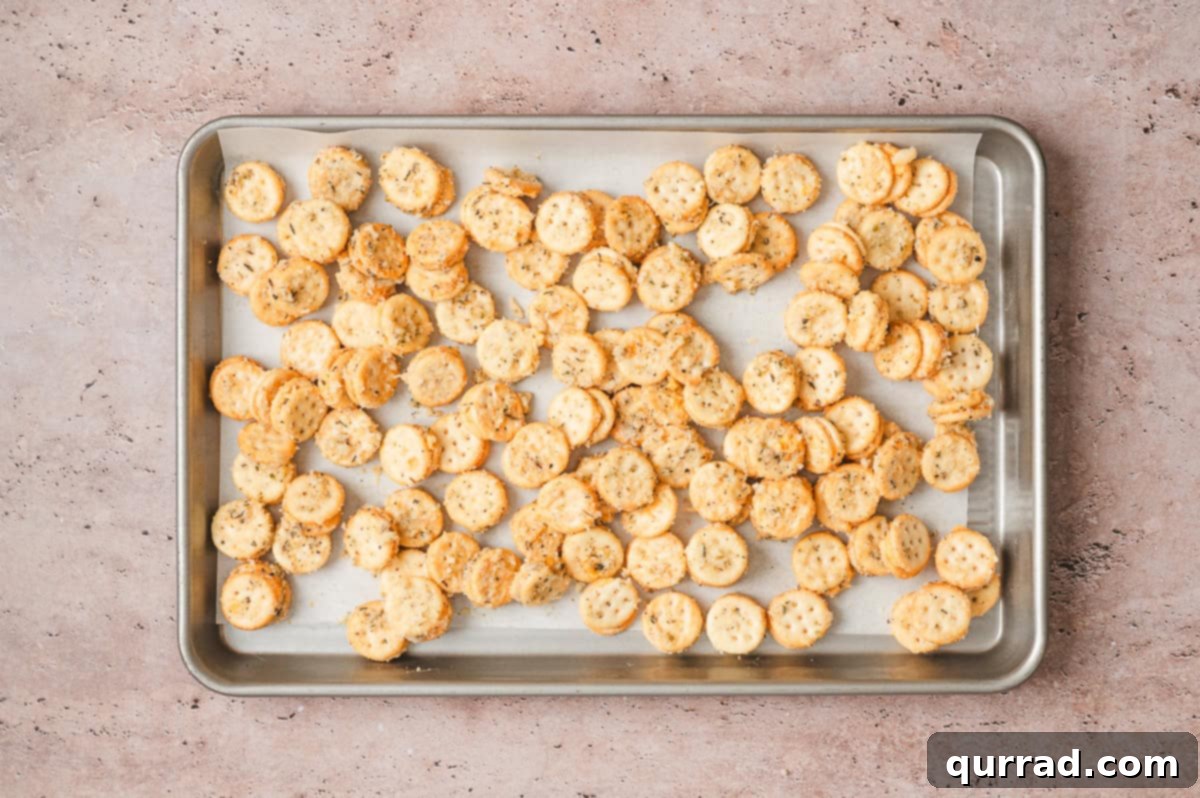 Garlic Bread Bites 7 Seasoned Ritz Bits spread in a single layer on a parchment lined baking sheet before baking