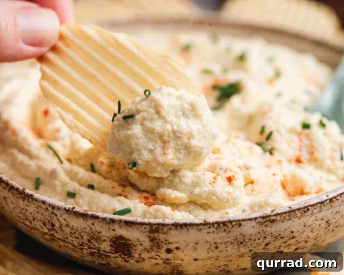 Deviled Egg Inspired Dip 8 Deviled egg dip on a chip, ready to be eaten.