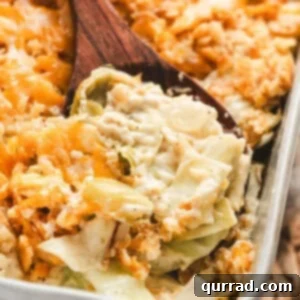 A wooden spoon scooping creamy cabbage casserole out of a baking dish.