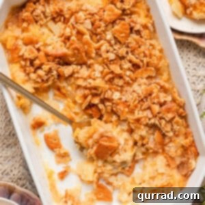 Overhead view of a southern pineapple casserole in a baking dish with a spoon and some of the casserole removed.
