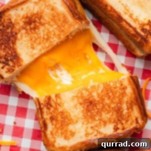 The Happiest Grilled Cheese on Earth 3 Overhead view of a copycat Disneyland grilled cheese sandwich sliced in half with melted cheese connecting the two halves.