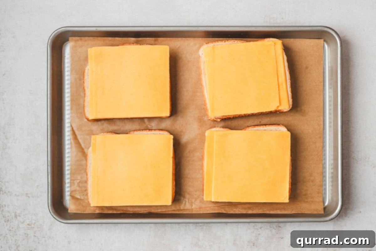 The Happiest Grilled Cheese on Earth 7 Sliced cheddar on four slices of Texas toast on a baking sheet.