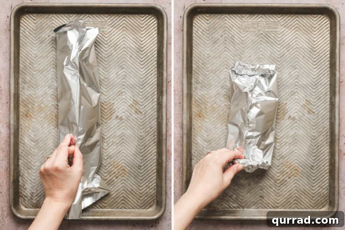 Hands meticulously folding a foil packet to seal the ingredients inside.