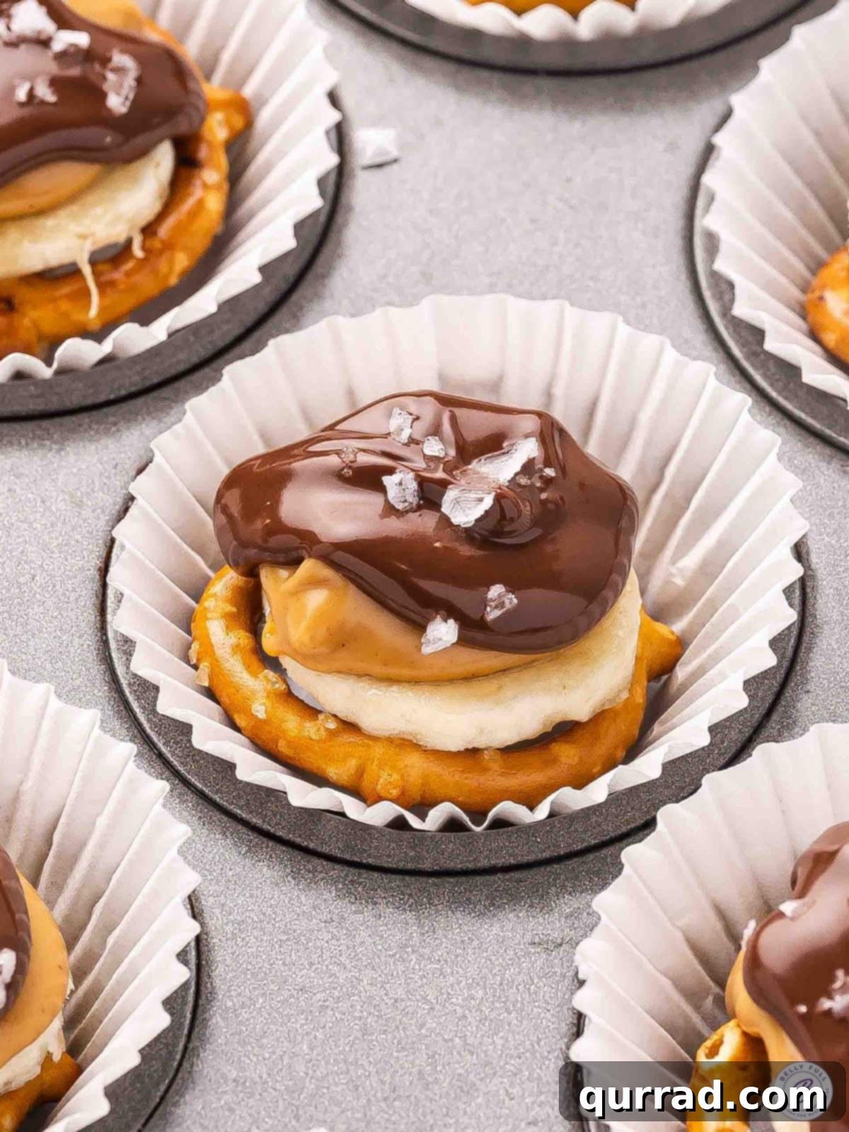 Side view of chocolate pretzel banana bites on a plate, showcasing the layers.