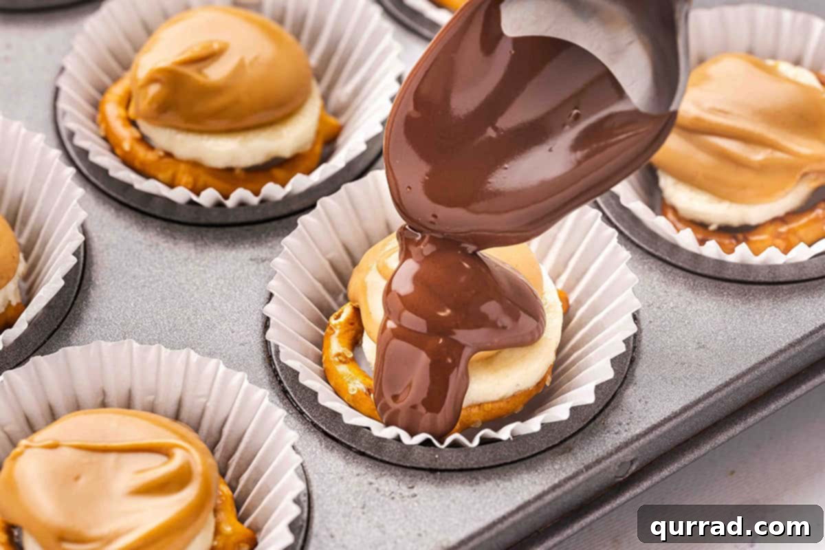 A spoon drizzling melted chocolate over the peanut butter and banana layers in a muffin liner.